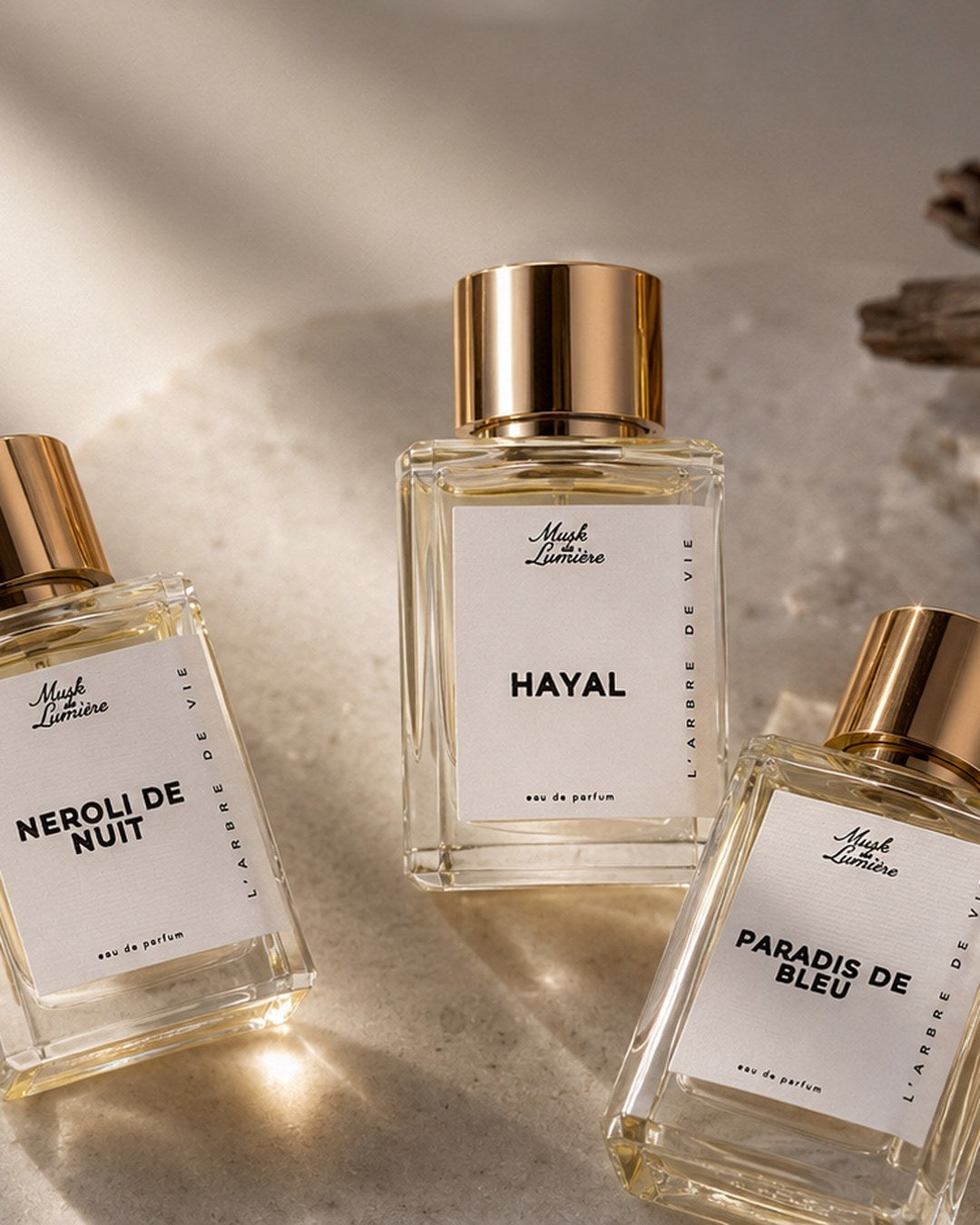 Néroli de Nuit, Hayal and Paradis de Bleu bottles in golden light — mobile hero, Musk de Lumière
