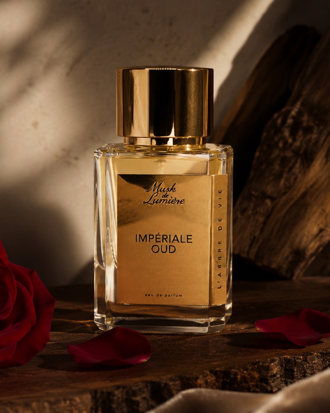 Impériale Oud gold bottle with red rose petals — mobile hero, Musk de Lumière