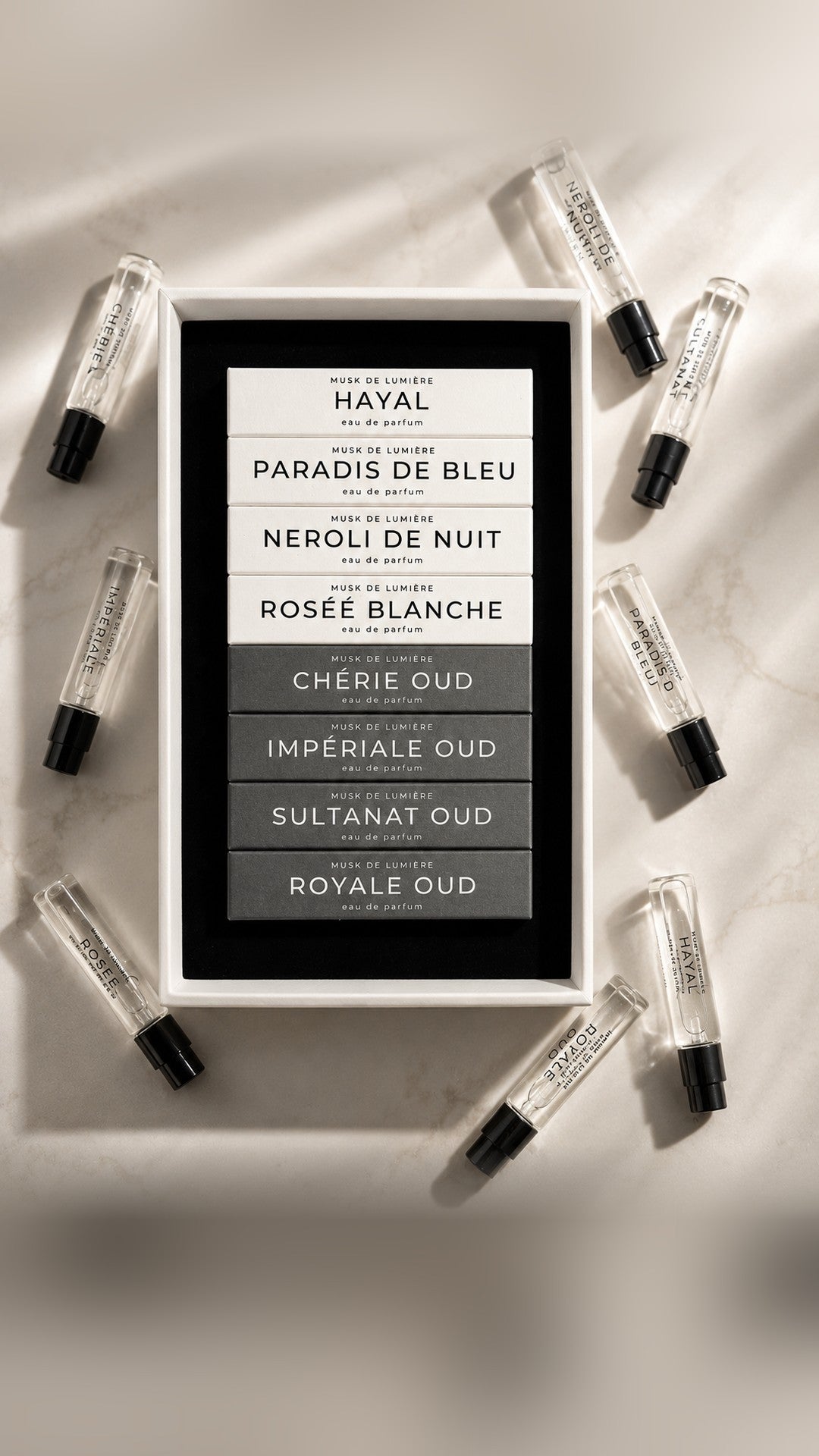 The L'Arbre de Vie Discovery Set open on marble — eight chapters with 2.5 ml vials — Musk de Lumière mobile hero